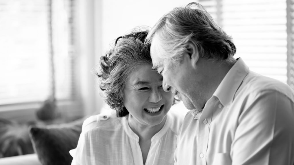 older couple smiling foreheads touching